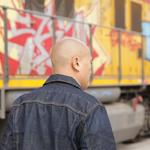 DOSA posing in front of a graffiti train